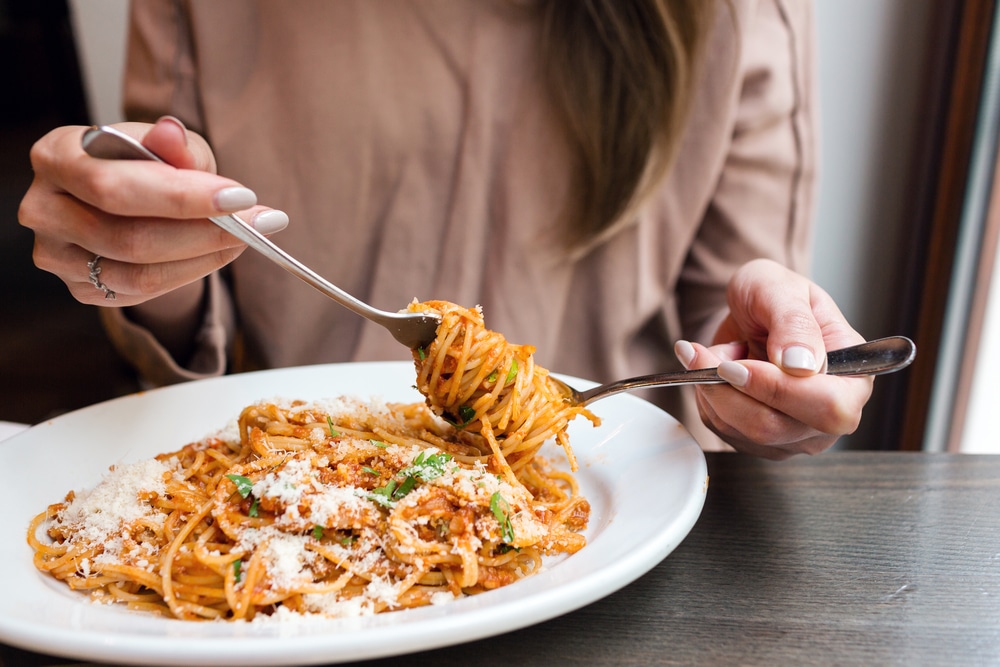 Woman enjoys fresh pasta from Via Rosa 11, one of the best restaurants on Bainbridge Island for lunch.