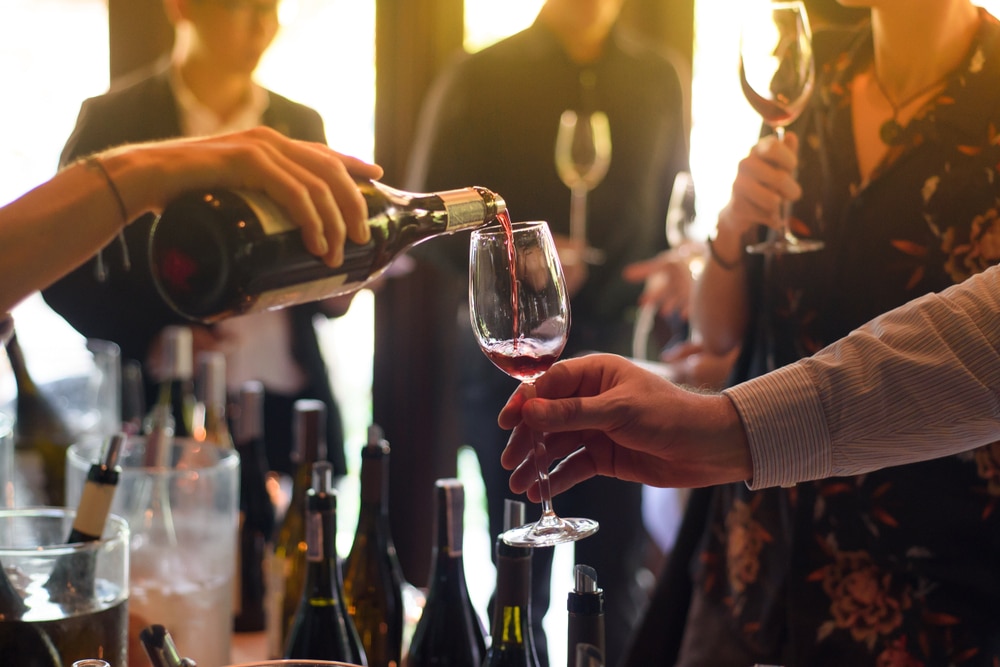 Server pouring wine for tasting at one of the washington state wineries on Bainbridge Island.